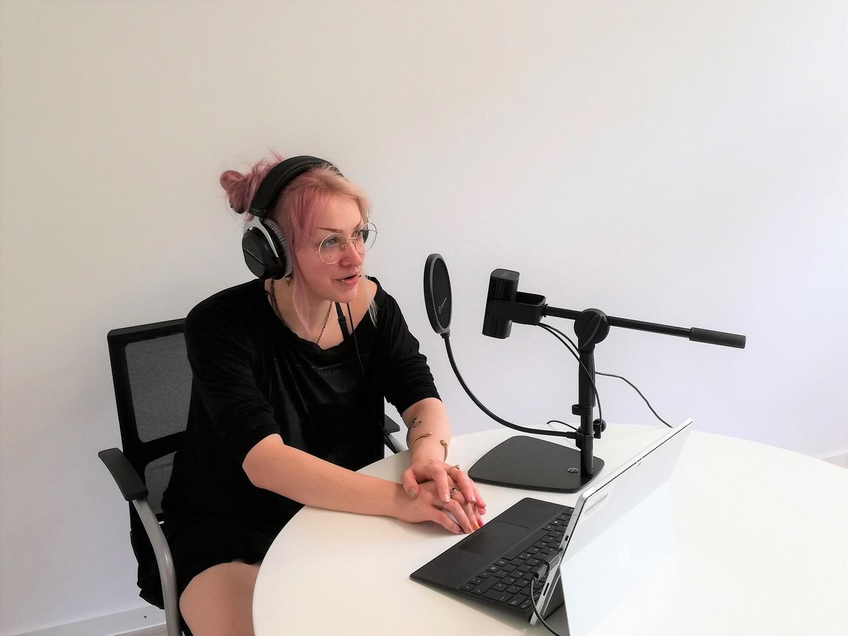 zur Vergrößerungsansicht des Bildes: Studentin mit Kopfhörern, Mikrophon und Laptop bei einer Podcast-Aufnahme