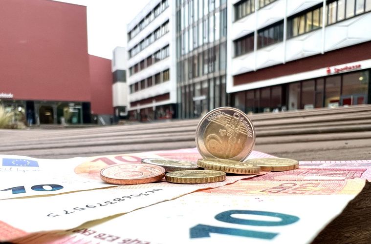 Münzen und Geldscheine auf einer Bank im Innenhof auf dem Campus Augustusplatz.