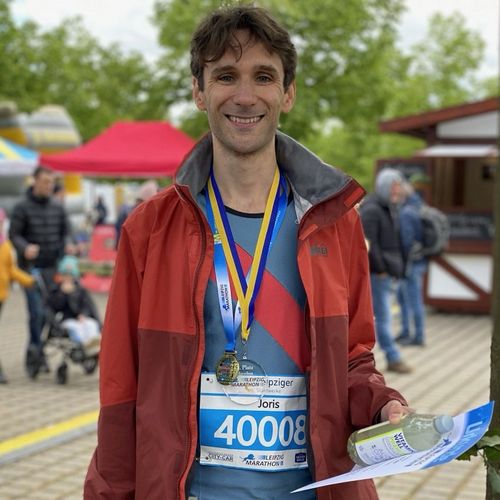 Joris Spigt gewinnt den zweiten Platz auf dem Leipzig Marathon und trägt eine Medaille um den Hals und eine Urkunde in der Hand