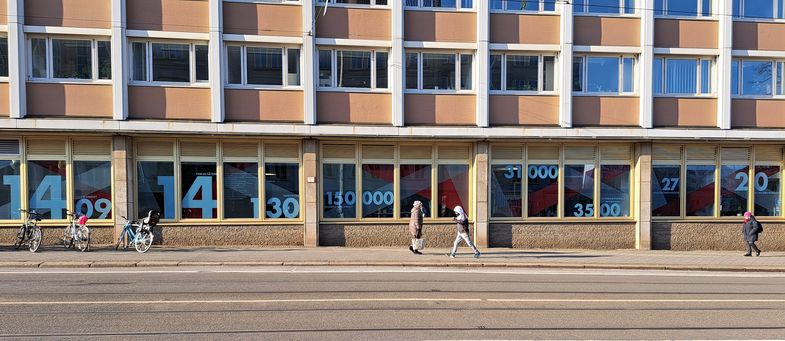 Zu sehen ist die breite Fensterfront in der Goethestraße 6. Sie ist mit Zahlen beklebt, die die Erfolge der Universität wiedergeben.