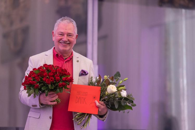 Jürgen Ronthaler, der die Letzte Vorlesung gehalten hat, mit zwei Blumensträußen. 