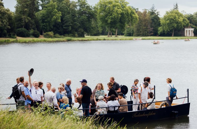 Zu sehen sind die Mitglieder der Universitätsgesellschaft auf ihrer Exkursion in einem Boot auf einem Teich.