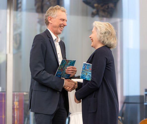 Auf dem Bild sind Die Rektorin der Universität Leipzig, Prof. Dr. Eva Inés Obergfell und IfL-Direktor Prof. Dr. Sebastian Lentz händeschüttelnd zu sehen.