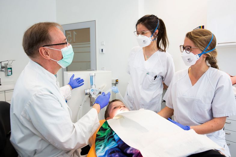 Zahnbehandlung an einem Kind vor Studierenden