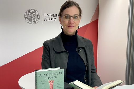 Julia Schmidt-Funke, Professorin für Geschichte der Frühen Neuzeit an der Universität Leipzig, blättert in Tore Renbergs Roman "Die Lungenschwimmprobe". Links im Bild: die norwegische Originalausgabe. 