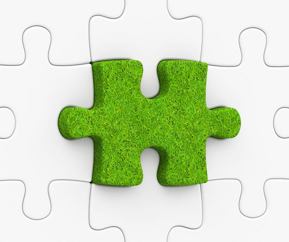 Auf dem Bild ist ein grünes Puzzleteil unter weißen Puzzleteilen zu sehen.