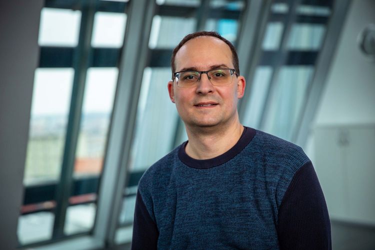 Daniel Král steht in einem Gebäude der Universität Leipzig vor einem Fenster. 