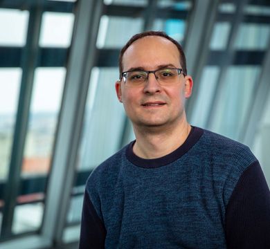 Daniel Král steht in einem Gebäude der Universität Leipzig vor einem Fenster.