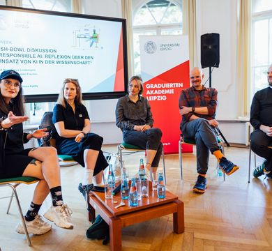 Foto: Christian Hüller/Universität Leipzig Zu sehen sind fünf Diskutierende in einer Stuhlreihe auf dem Podium