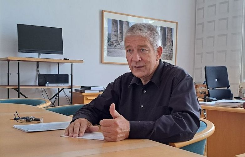 Mann sitzt am Tisch in einem Büro