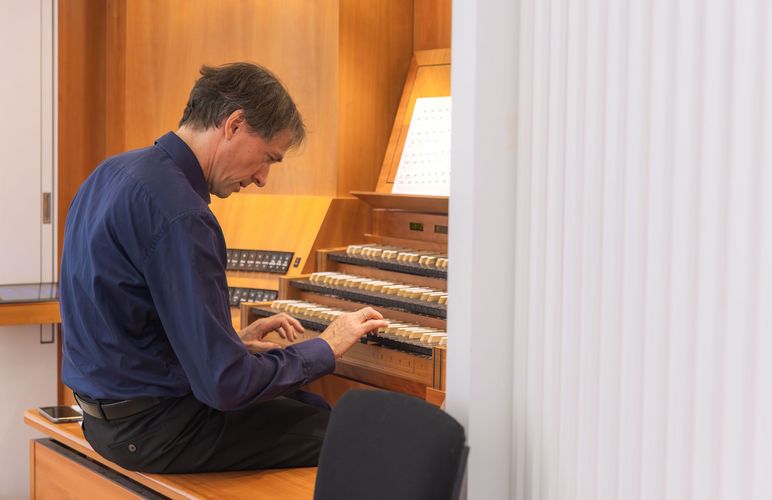 David Timm sitzt vor einer großen Orgel.