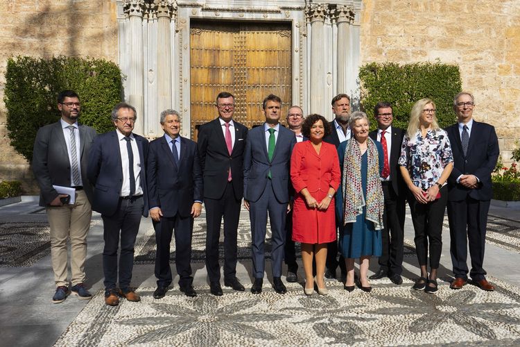 12 Personen stehen vor einem historischen Gebäude in Spanien