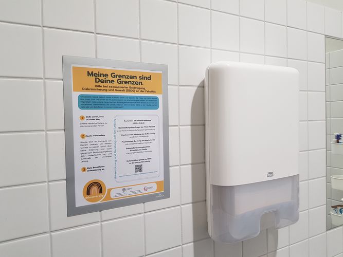 Plakat hängt über einem Waschbecken in der Damentoilette