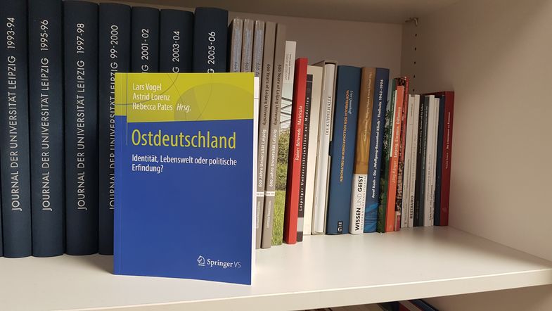 Auf derm Bild ist das blau-grüne Buch "Ostdeutschland" in einem Bücheregal zu sehen.