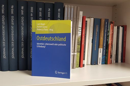 Auf derm Bild ist das blau-grüne Buch "Ostdeutschland" in einem Bücheregal zu sehen.