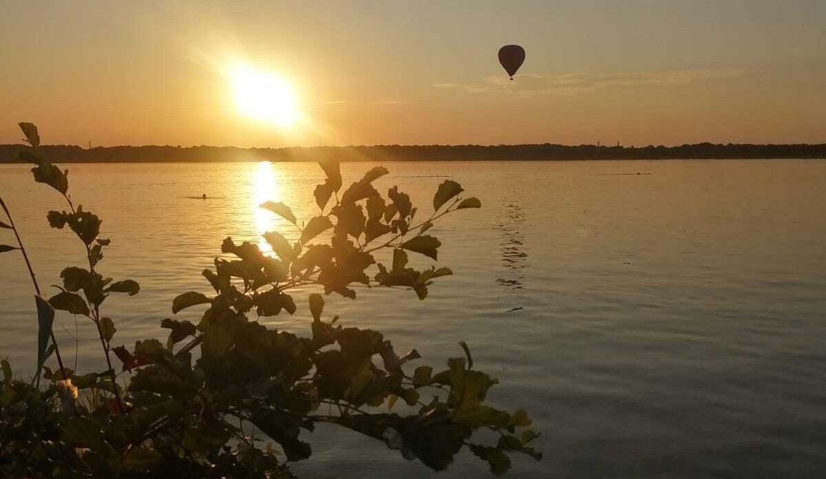 zur Vergrößerungsansicht des Bildes: Zu sehen ist der Cospudener See, im Hintergrund geht die Sonne unter