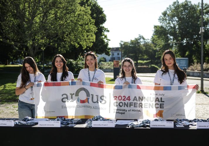 Fünf portugiesische Studentinnen halten ein Transparent zur Arqus-Konferenz
