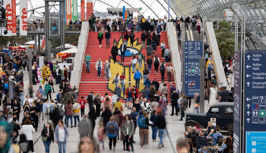 Zu sehen ist die Glashalle der Leipziger Messe zur Buchmesse mit Publikum.