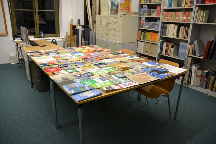Auf dem Bild ist ein Tisch mit verschiedenen Karten zu sehen.