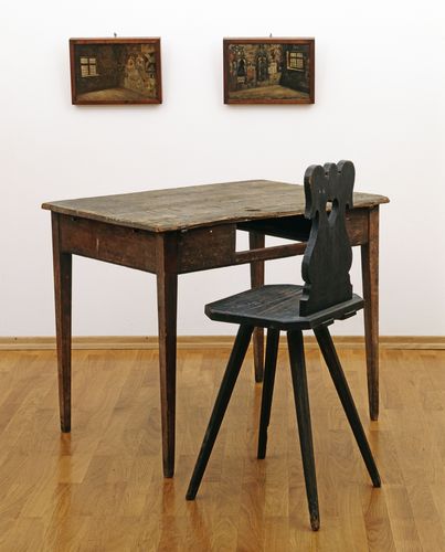 Auf dem Bild ist ein spartanischer Karzerstuhl mit Tisch zu sehen. Studierende mussten im 19. Jahrhundert ihre Haftstrafen im Karzer, dem Universitätsgefängnis, "absitzen".