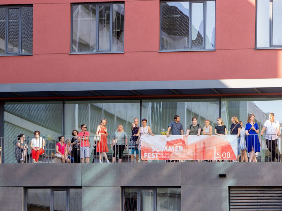 zur Vergrößerungsansicht des Bildes: Blick auf die Terrasse der Wirtschaftswissenschaftlichen Fakultät voller Menschen beim Sommerfest.