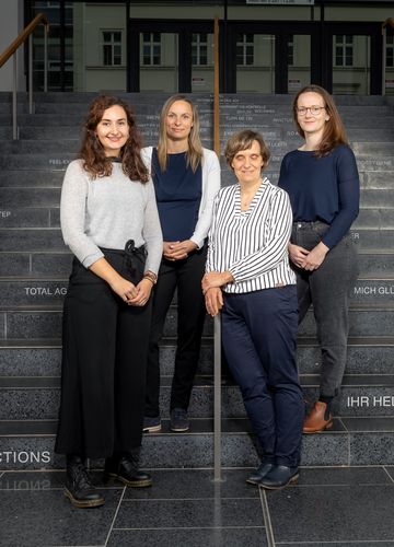 Vier Mitarbeiterinnen des Betrieblichen Gesundheitsmanagements stehen auf Stufen für ein Teamfoto
